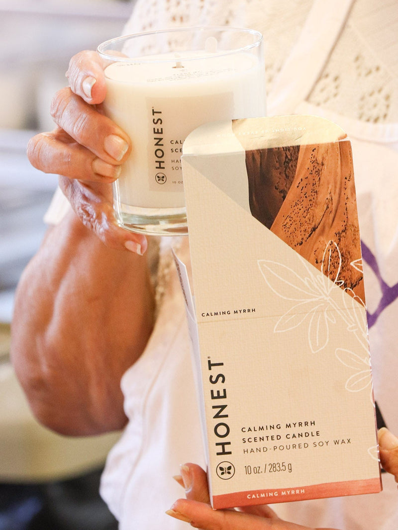 Person holding an 'Honest' brand candle and soap bar.